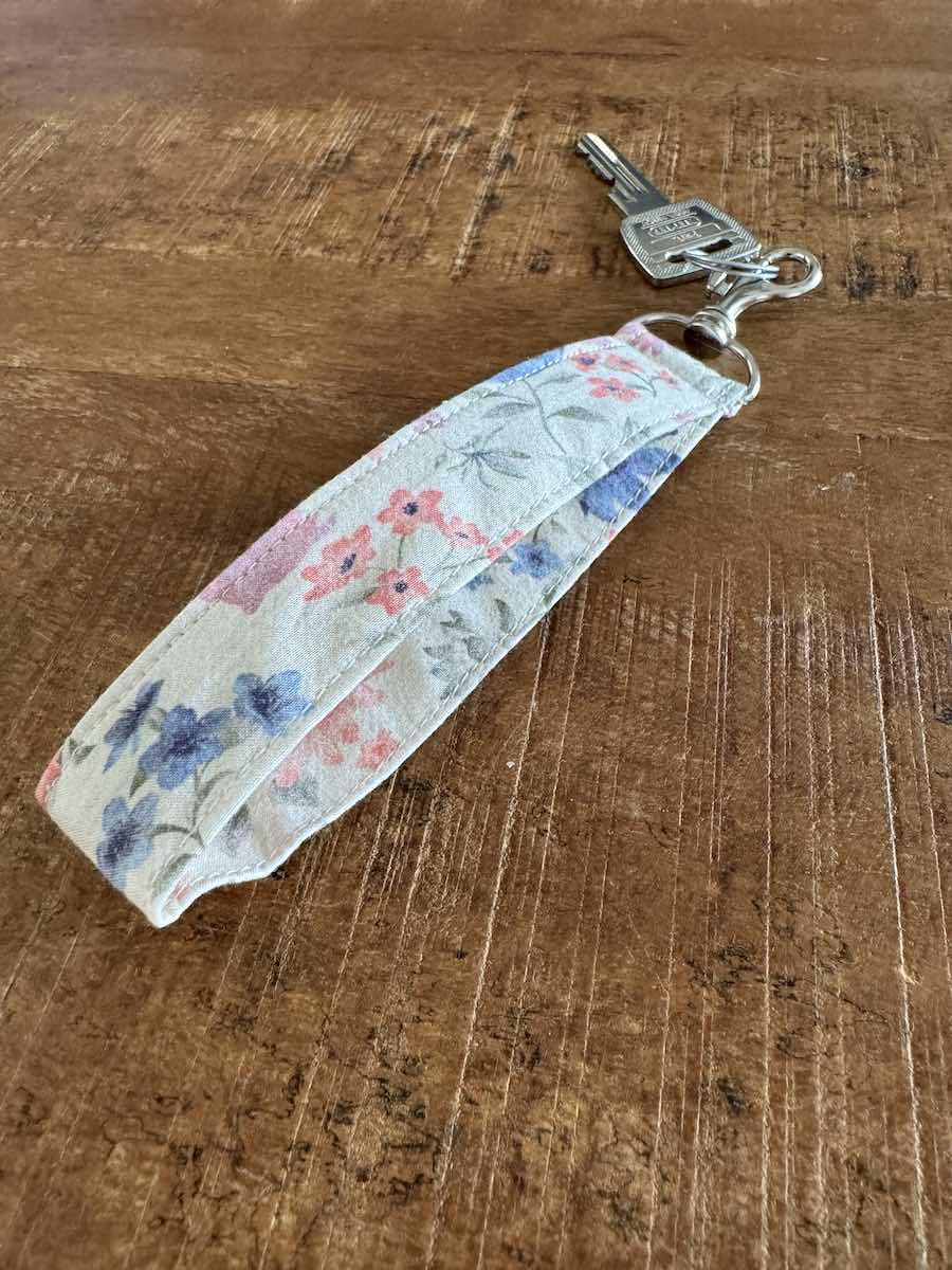 Handgemaakte witte polssleutelhanger met roze en blauwe bloemen Craftketeers